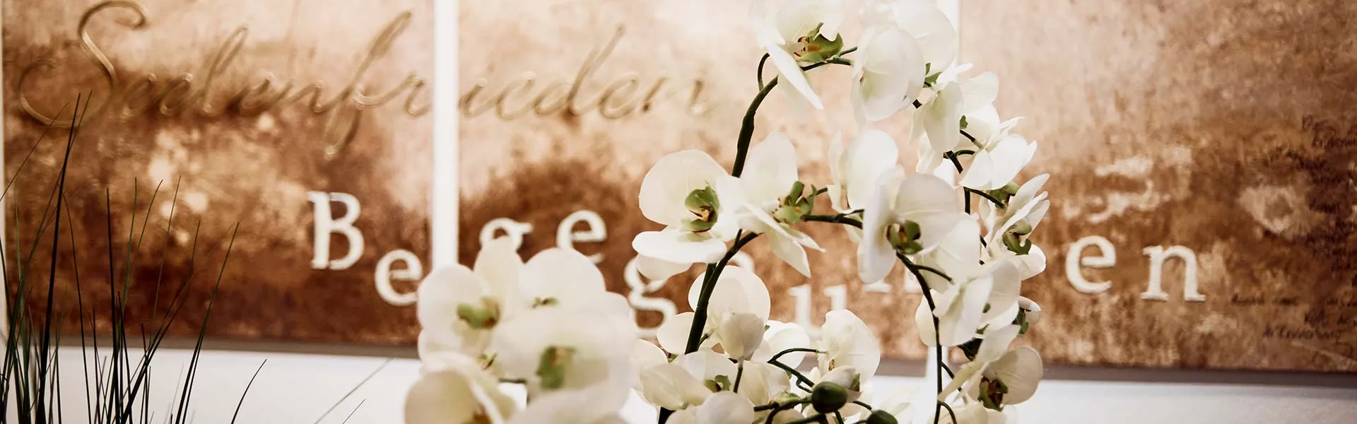 Schriftzug „Seelenfrieden“ mit weißen Orchideen in unseren Abschiedsräumen